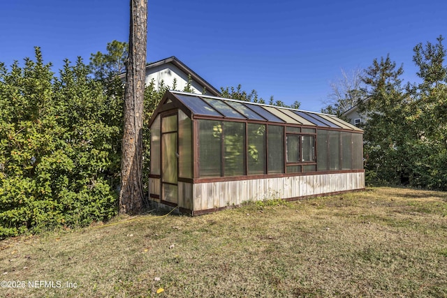 view of side of home featuring an outdoor structure and a lawn