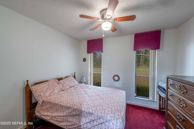 bedroom featuring ceiling fan, a textured ceiling, and dark colored carpet