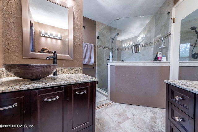 bathroom with tiled shower and vanity