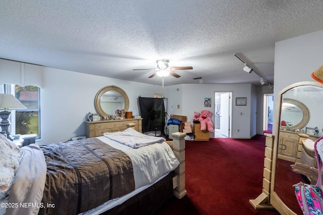 bedroom with ceiling fan, track lighting, a textured ceiling, and dark colored carpet