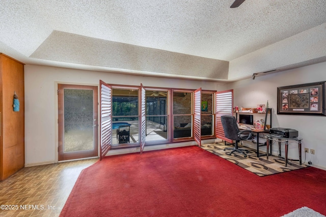 office with ceiling fan, a raised ceiling, and a textured ceiling