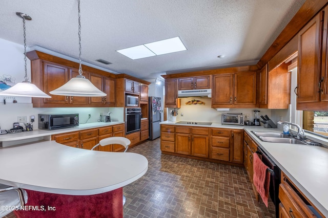 kitchen with sink, a skylight, a textured ceiling, pendant lighting, and black appliances