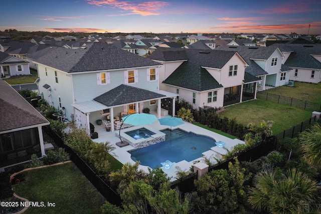 exterior space featuring an in ground hot tub, a yard, and a patio area