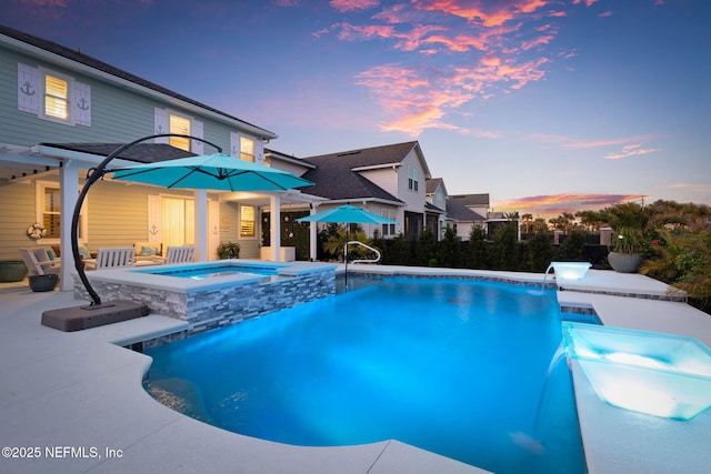 pool at dusk with an in ground hot tub, pool water feature, and a patio