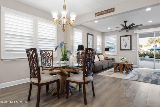 dining space with hardwood / wood-style flooring and ceiling fan with notable chandelier