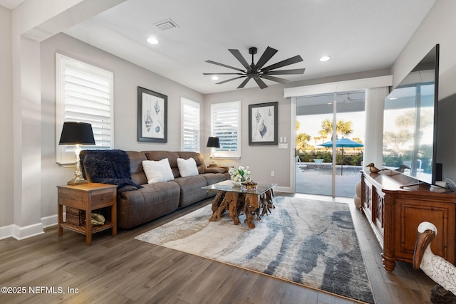 living room with dark hardwood / wood-style floors and ceiling fan