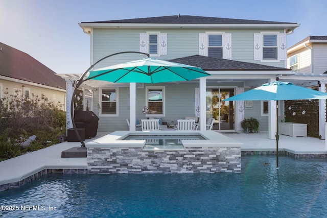 back of property with a swimming pool with hot tub and a patio