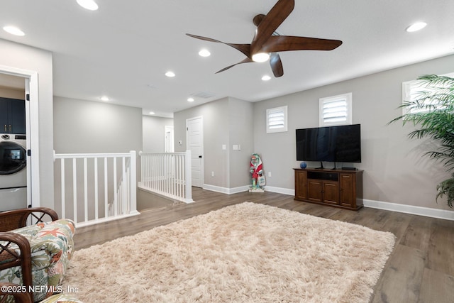 interior space with washer / dryer, dark hardwood / wood-style floors, and ceiling fan