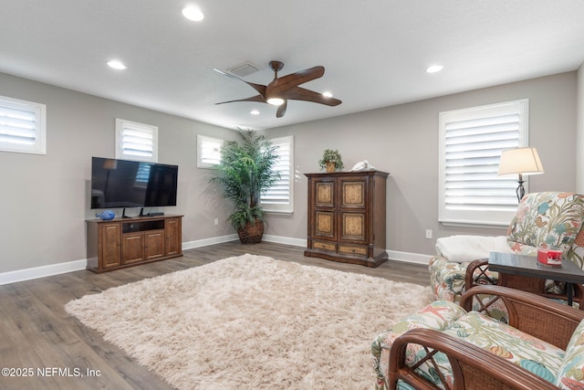 living room featuring dark wood-type flooring and ceiling fan