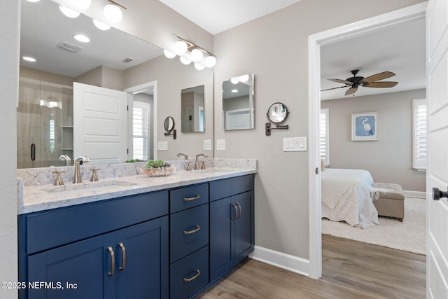 bathroom with an enclosed shower, hardwood / wood-style floors, vanity, and ceiling fan