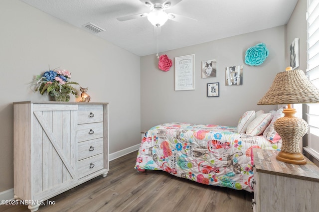 bedroom with dark hardwood / wood-style flooring and ceiling fan