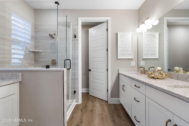 bathroom with a shower with door, vanity, and hardwood / wood-style floors