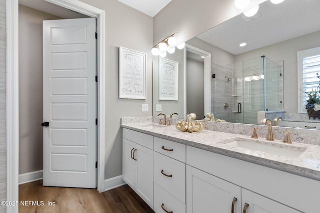 bathroom featuring vanity, wood-type flooring, and walk in shower