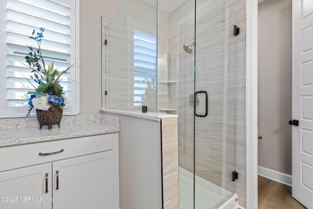 bathroom featuring a shower with door, vanity, and hardwood / wood-style floors