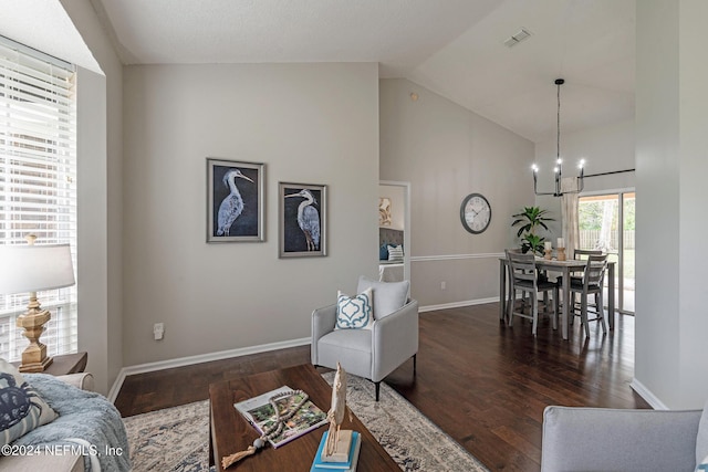 living room featuring lofted ceiling, dark wood-type flooring, and an inviting chandelier