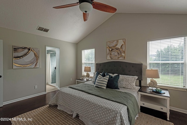 bedroom featuring multiple windows, ensuite bath, dark hardwood / wood-style flooring, and ceiling fan