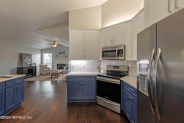 kitchen featuring white cabinetry, lofted ceiling, appliances with stainless steel finishes, and blue cabinetry