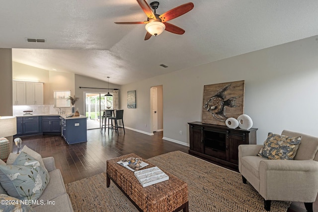 living room with ceiling fan, sink, dark hardwood / wood-style flooring, and vaulted ceiling