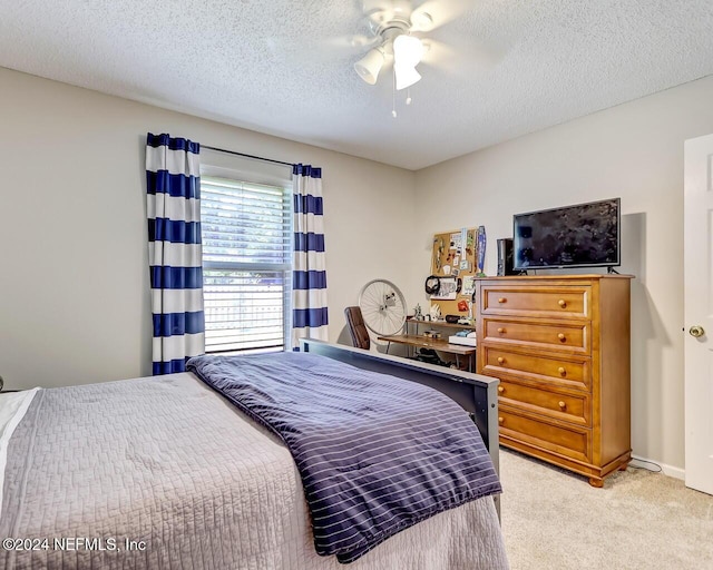 carpeted bedroom featuring ceiling fan and a textured ceiling