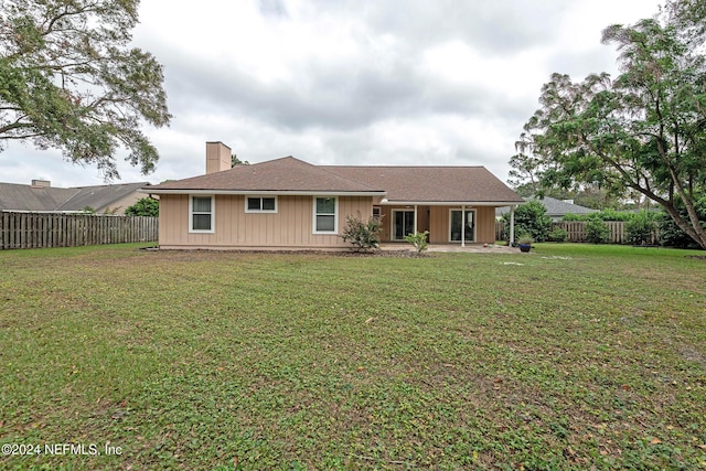 rear view of house with a yard