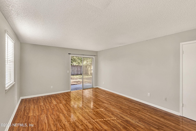 spare room with wood-type flooring and a textured ceiling