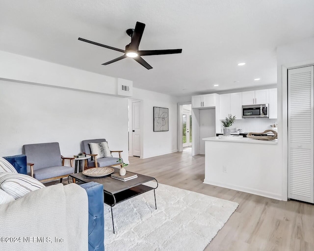 living room with ceiling fan and light hardwood / wood-style flooring