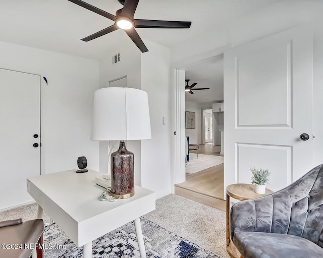 carpeted office space featuring ceiling fan