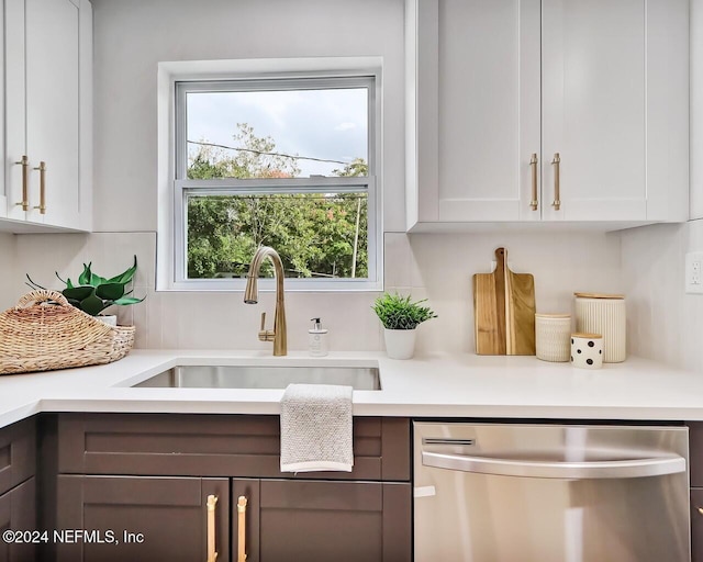 kitchen featuring sink, stainless steel dishwasher, and white cabinets