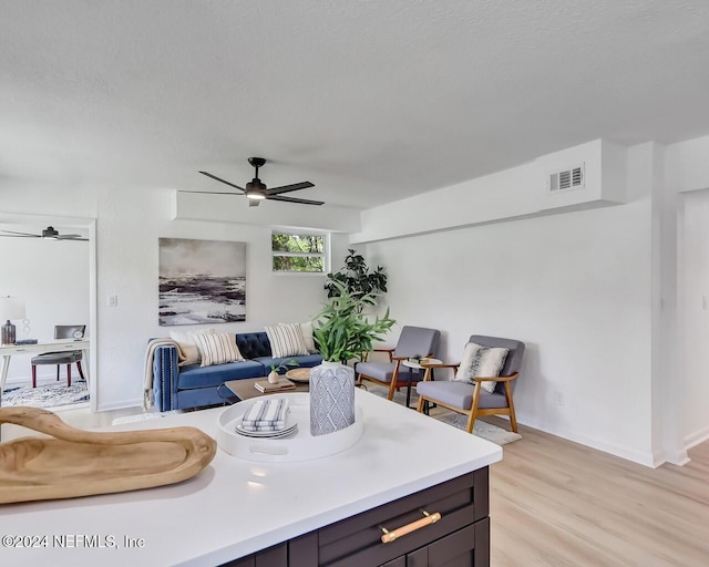 living room featuring ceiling fan and light hardwood / wood-style floors