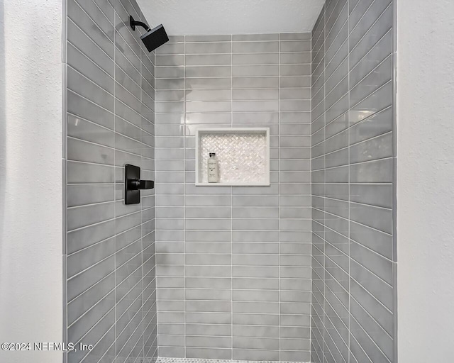 bathroom featuring tiled shower and a textured ceiling