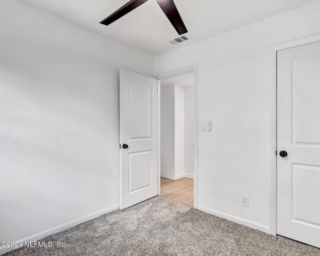 unfurnished bedroom featuring ceiling fan and light colored carpet