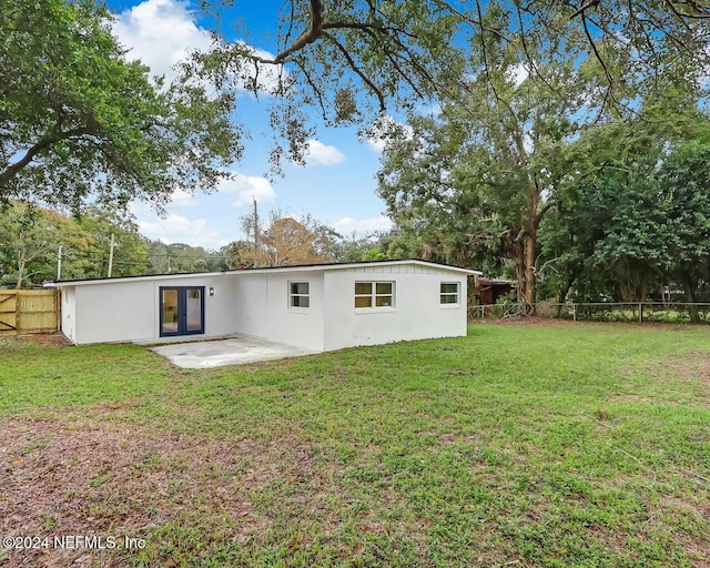 rear view of house featuring a yard and a patio area