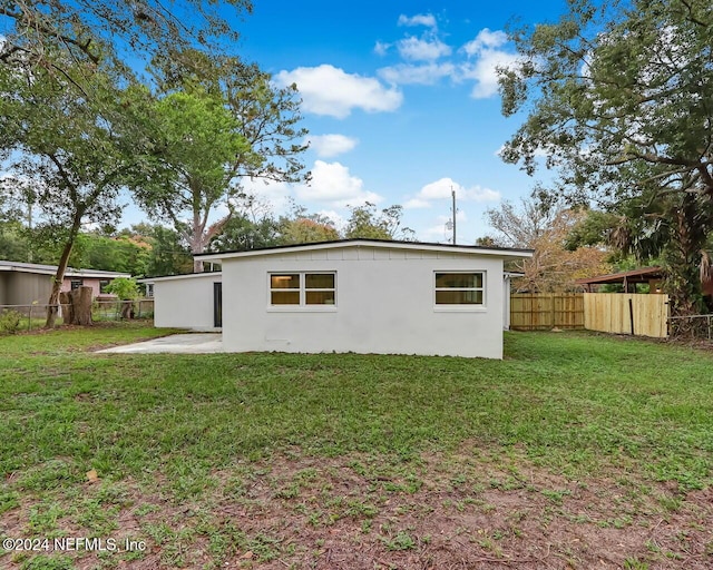 rear view of property with a lawn