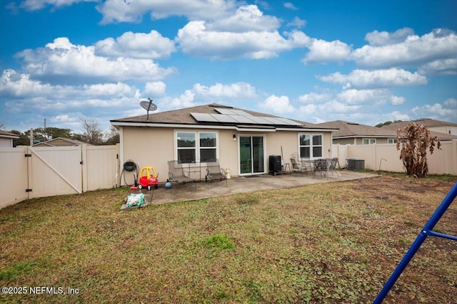 back of house with a playground, a yard, central air condition unit, a patio area, and solar panels