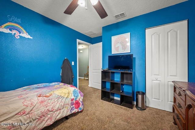 carpeted bedroom with a textured ceiling, a closet, and ceiling fan