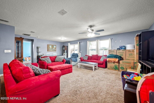 carpeted living room featuring ceiling fan and a textured ceiling