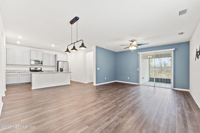 unfurnished living room featuring ceiling fan and light hardwood / wood-style flooring