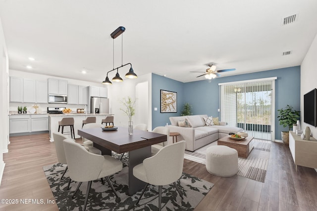 dining area with ceiling fan and light hardwood / wood-style floors