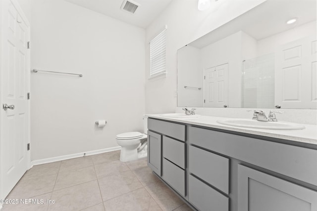 bathroom with tile patterned floors, vanity, toilet, and a shower with door