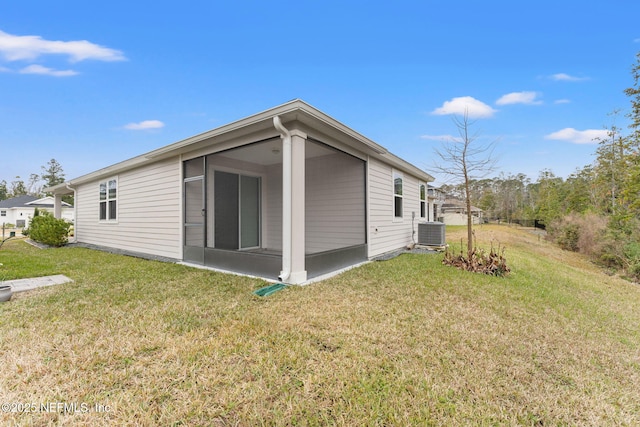 back of house with a lawn, a sunroom, and central air condition unit