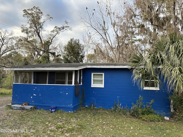 view of side of home with a sunroom