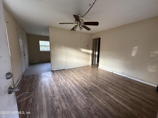 spare room with dark wood-type flooring and ceiling fan