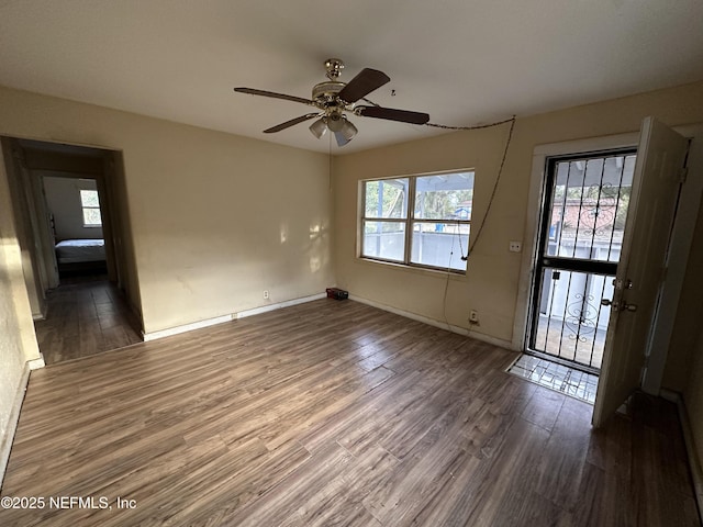 empty room with dark hardwood / wood-style floors and ceiling fan