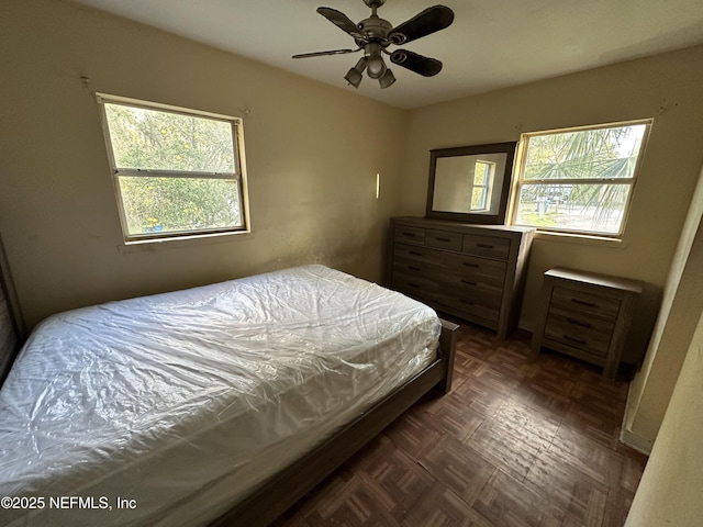 bedroom featuring ceiling fan and dark parquet floors