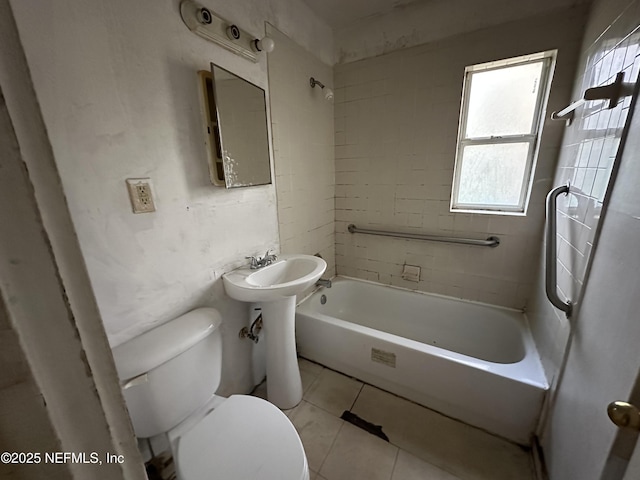 bathroom featuring tiled shower / bath combo, tile patterned floors, and toilet