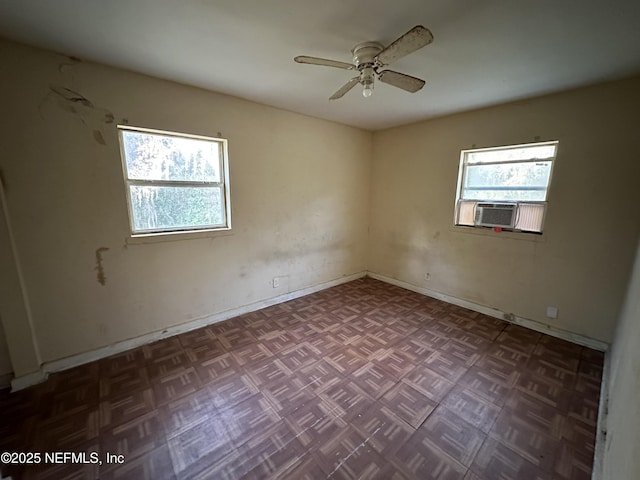 spare room with ceiling fan, a healthy amount of sunlight, cooling unit, and dark parquet floors