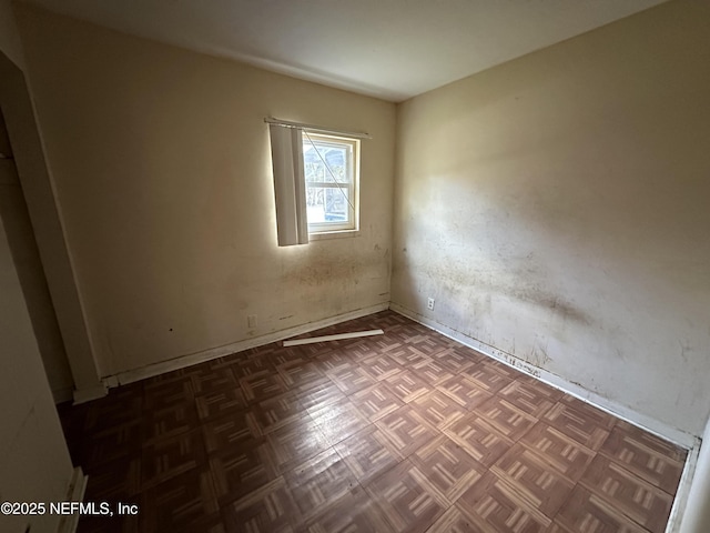 spare room with dark parquet floors