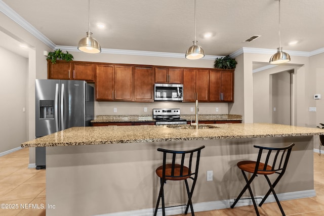 kitchen featuring a kitchen bar, decorative light fixtures, and appliances with stainless steel finishes