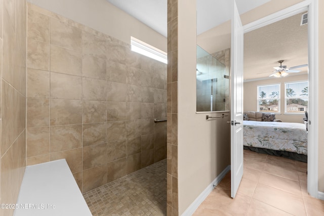 bathroom featuring ceiling fan, tile patterned floors, and a tile shower