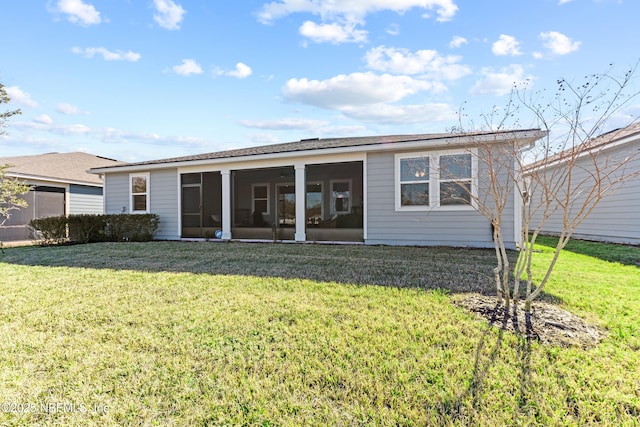 rear view of property featuring a yard and a sunroom